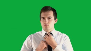Adam yeşil ekranda kravatını düzeltir.