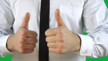 Takım elbiseli ve kravatlı adam başparmağını kaldırıyor.