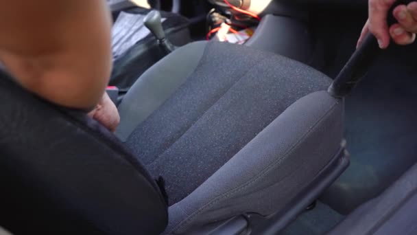 En man dammsuger insidan av sin bil — Stockvideo