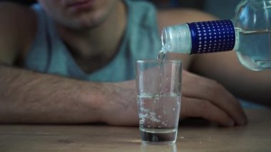 Bir adam bir bardak votka ve içki doldurur.