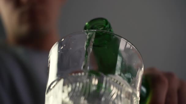 Un homme verse de l'alcool dans un verre et le boit. — Video