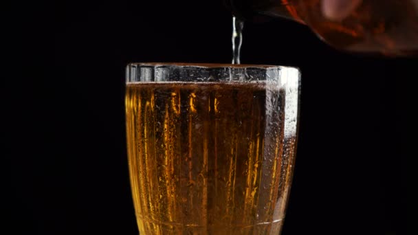 Lidská ruka nalévá pivo do skleněného poháru — Stock video