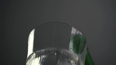 Bir adam şişeden bardağa votka dolduruyor.