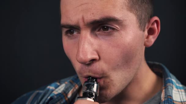 Młody biały człowiek palenie vape na czarny tło — Wideo stockowe