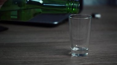 Bir adam bardağa votka doldurur. alkolizm kavramı