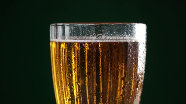 Taza de cristal de la cerveza se coloca en el fondo negro — Vídeos de Stock