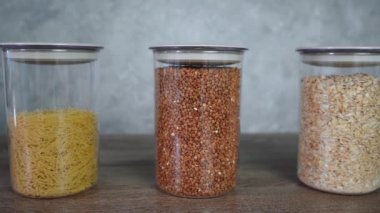Tahta bir masada duran kavanozlardaki tahıllar