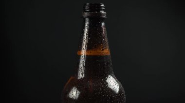 Siyah arka planda plastik bira şişesi.