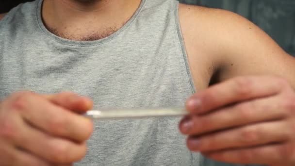 Um homem mede a sua temperatura — Vídeo de Stock