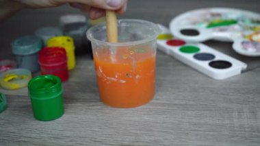 Sanatçı pis bir fırçayı suya batırır.