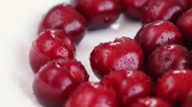 Bir avuç kiraz beyaz bir tabakta döner.