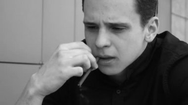 Sokakta sigara içen bir adam. siyah beyaz video
