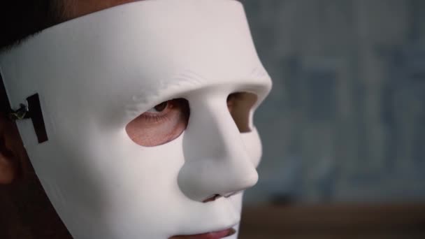 Um homem esconde a sua identidade sob uma máscara anónima — Vídeo de Stock