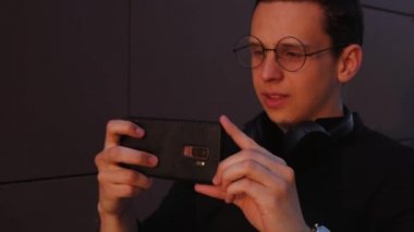 Adam telefonuyla günbatımını çekiyor.