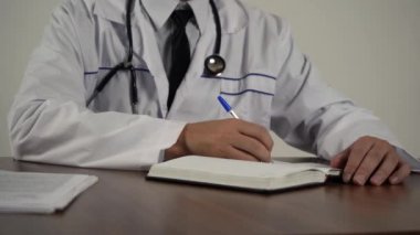 Doktor belgeleri ofisinde, masada tutuyor.