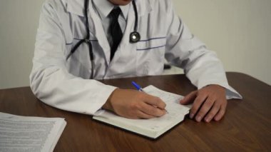 Doktor belgeleri ofisinde, masada tutuyor.