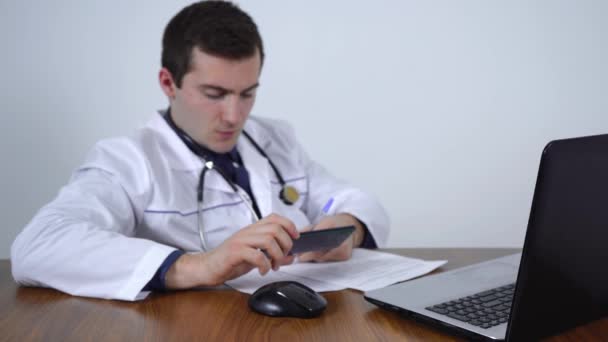 Лікар веде облік документів з телефону. відео поза фокусом — стокове відео