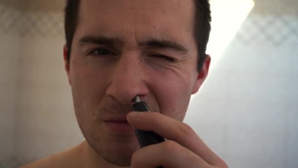 Muž stříhá chloupky v nose speciálním střihačem — Stock video