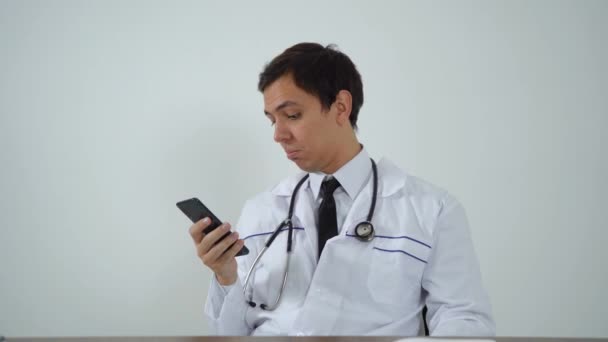 Medico utilizza il telefono mentre seduto in ufficio — Video Stock