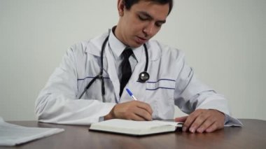 Doktor belgeleri ofisinde, masada tutuyor.