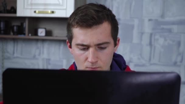 Чоловік використовує ноутбук, сидячи в кімнаті — стокове відео