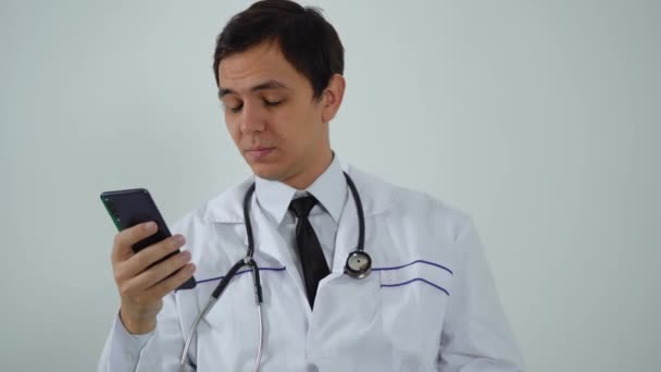 Médico usa o telefone enquanto está sentado no escritório — Vídeo de Stock