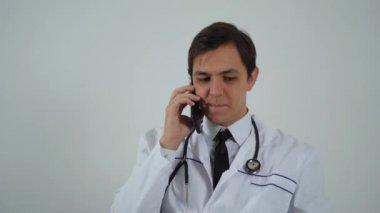 Neşeli erkek doktor telefonda konuşuyor.