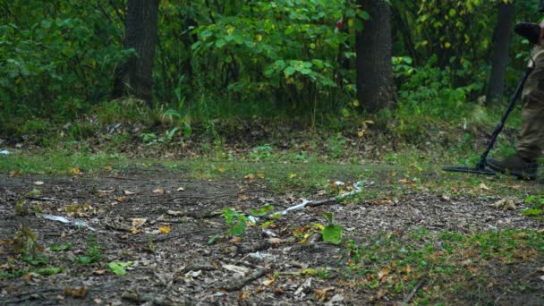사람은 금속 탐지기를 가지고 숲 속을 걸어 다닌다 — 비디오
