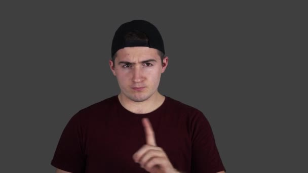 Man i t-shirt visar en hotfull gest genom att skaka sitt pekfinger. — Stockvideo
