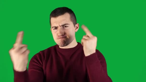 Чоловік показує поганий жест пальцями на зеленому фоні — стокове відео
