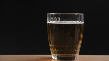 Siyah zemin üzerinde bira olan cam kadehler.