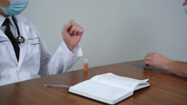 Médico vende medicamentos para um paciente em seu escritório — Vídeo de Stock