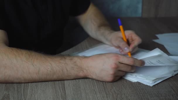 Linkshänder füllt Papier aus, während er am Tisch sitzt — Stockvideo