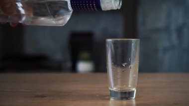 Adam bardağa votka dolduruyor.