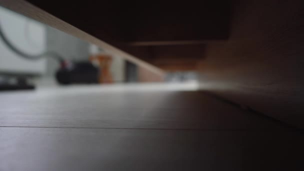 Человек пылесосит пол под кроватью — стоковое видео