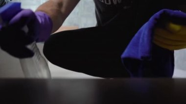 Dairenin genel temizliği. Erkek eli komodini tozdan temizler.