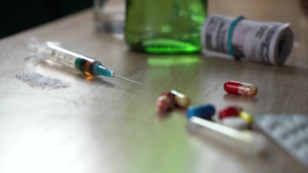 Seringue avec héroïne cocaïne et pilules debout sur la table après une fête. mauvaises habitudes et concept de toxicomanie — Video
