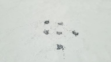 Balıkçılar balık tuttuktan sonra buzdaki delikler.