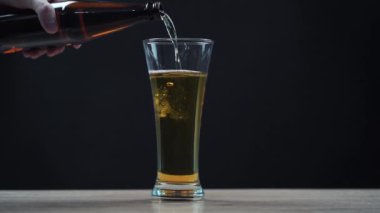 Adam cam şişeden bardağa bira dolduruyor. yavaş çekim