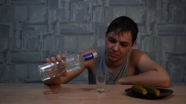 Алкоголик пьет водку со скорбью сидя за столом — стоковое видео