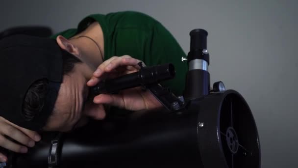 Un om care se uită la stele printr-un telescop . — Videoclip de stoc
