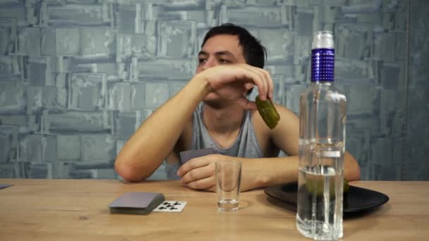 Drunk guy plays cards and drinks vodka — Stock Video