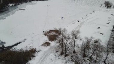 Balıkçılar buzun üzerinde oturur ve balık
