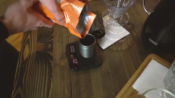 Un bărbat toarnă boabe de cafea într-un polizor manual de cafea — Videoclip de stoc