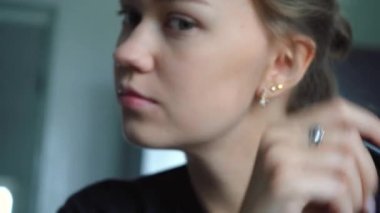 Kız yüzüne pudra sürer.