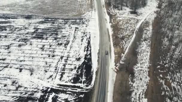 El dron vuela después del coche que conduce en la carretera en invierno — Vídeos de Stock