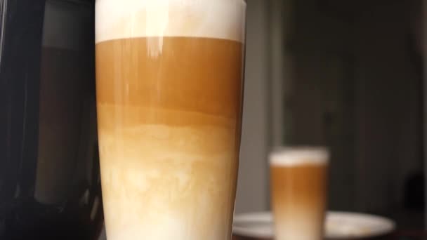 Latte em um copo de vidro está na mesa — Vídeo de Stock