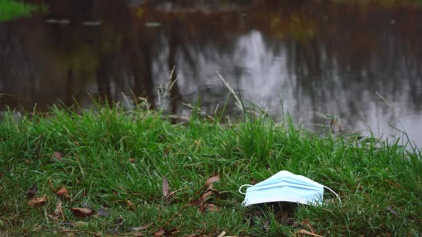 Nimmt ein Mann eine Maske auf, die vom Fluss geworfen wird. Sauberkeit und Ordnungskonzept — Stockvideo