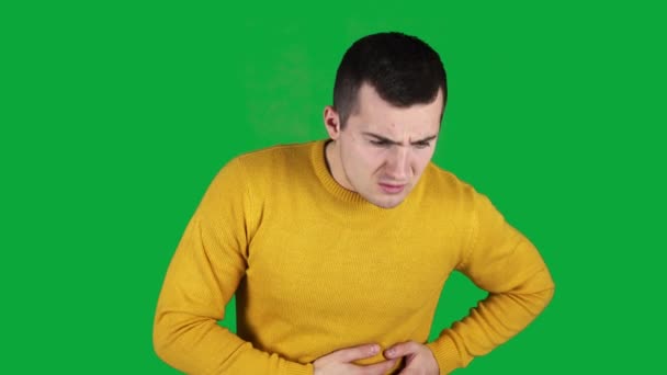 A man has a pain in his left side on a green screen — Stock Video
