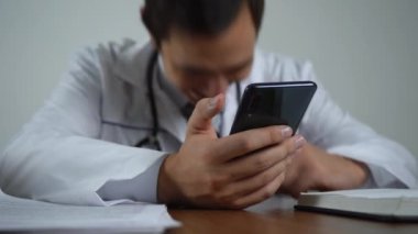 Erkek doktor telefonla gülüyor.